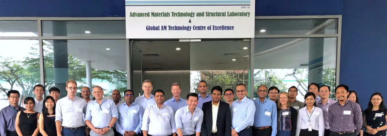 Joint industry program participants in front of the main entrance to the Global Additive Manufacturing Technology Centre of Excellence in Singapore
