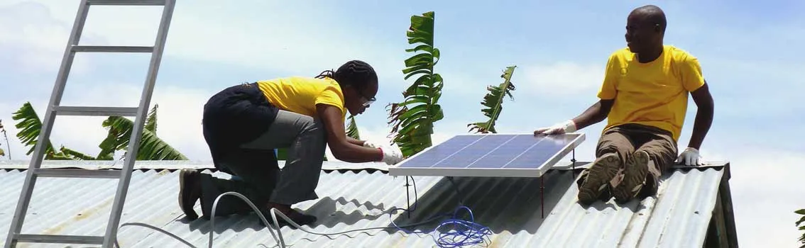 Workers install a rooftop solar panel